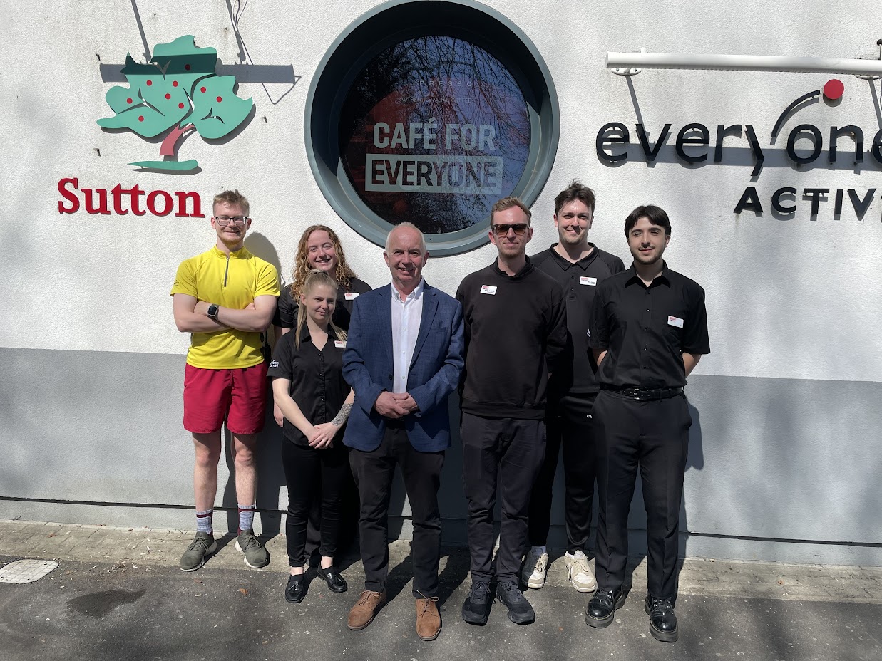 Leader of the Council, Councillor Barry Lewis outside Everyone Active leisure centre with staff members